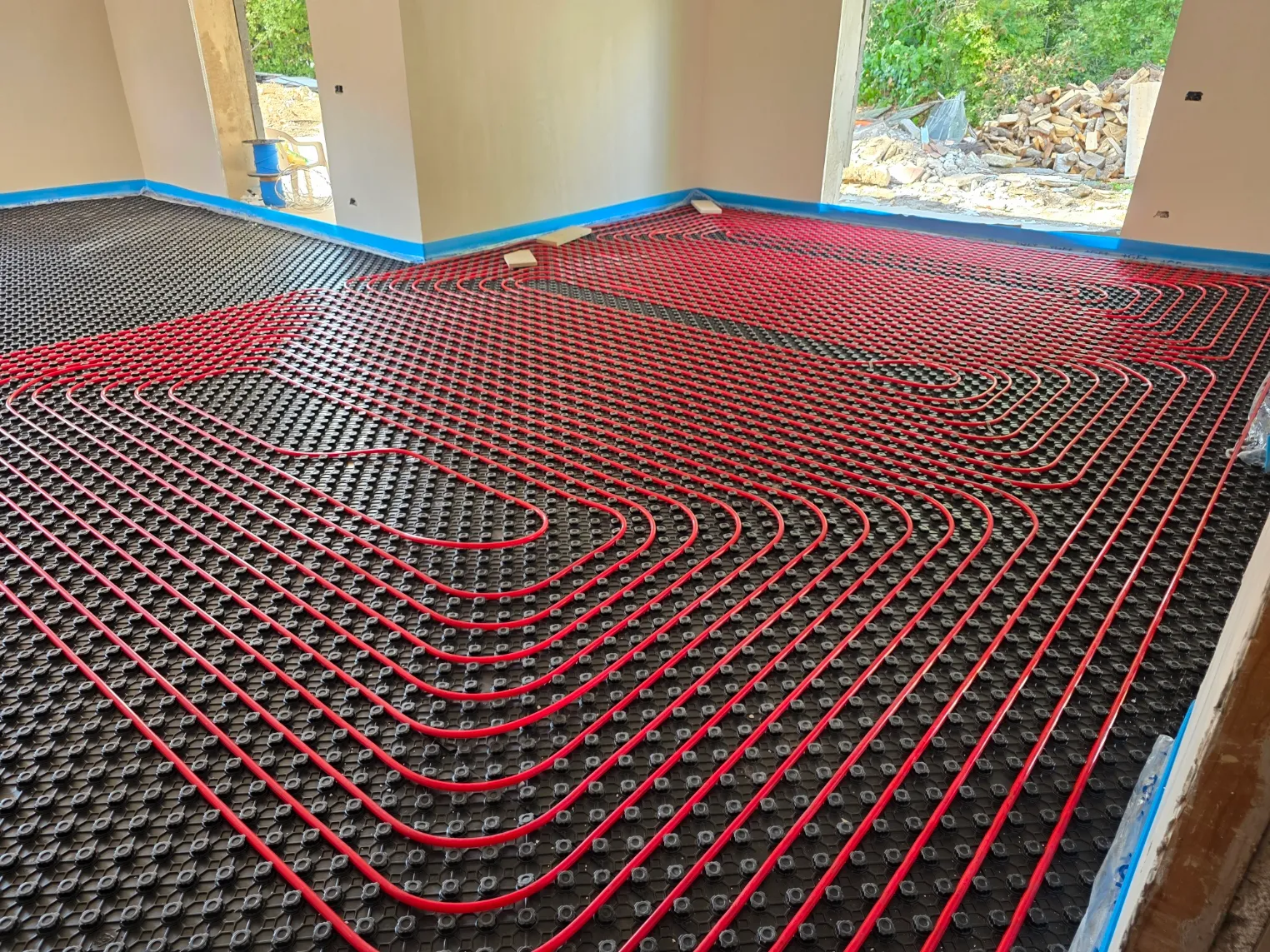 Posa dei circuiti di un impianto radiante a pavimento su pannello isolante bugnato